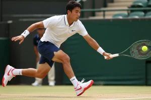 Pemain tenis pria sedang bergerak cepat dengan sepatu tenis nike